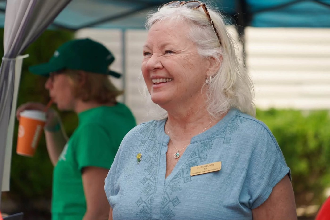 Susan Bloom at a campaign tent, wearing her Clarkstown Town Council Ward 3 name badge